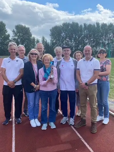 The family of the late Reg Burke gathered at the Queensway Stadium in Wrexham on 2nd August, to receive a trophy awarded after his posthumous induction into the North Wales Regional Athletics Council’s Hall of Fame. Pictured are Reg’s wife and family, with Wrexham A.C.’s track and field secretary Mike Robbins (left) and Club Chair Dave Edwards (centre), NWRAC secretary Paul Brooks (centre) and former Wales national coach Geoff Ward (back left) and his daughter (right). Photo: Bernie Jones.